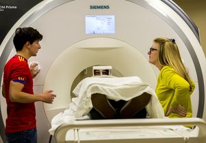 A research subject is prepared for an MRI as technician Jose Palomares and UCLA researcher Nancy Pike watch.