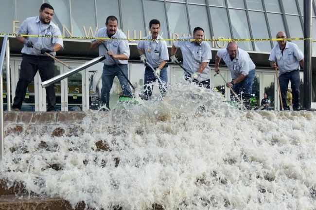 UCLA Facilities Management crew sweeps water away from Pauley Pavilion on July 29, 2014, following  water main break on Sunset Boulevard