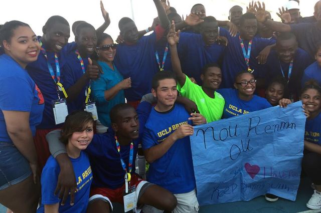 Team Haiti and First Star UCLA Bruin Guardian Scholars Academy students celebrating and holding a sign made by the students that says, “We Love You” in Creole on July 26. 