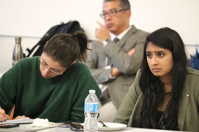 caption Medical students Samantha Mohammad, left, and Abhinaya Narayanan take notes during the social work orientation.
