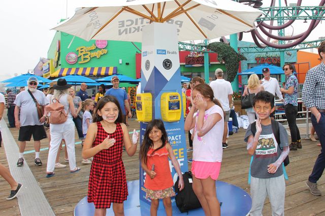 Kids use sun safety kiosk