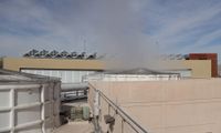 White circular fans sit above the cooling towers at the Lomas Chilled Water Plant. Water vapor leaves the towers caused by the system rejecting heat that is absorbed from campus.