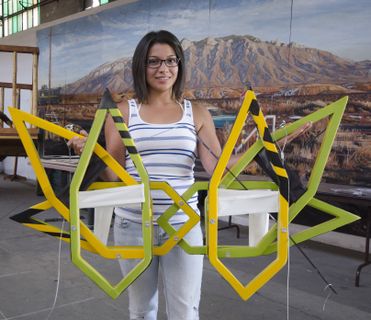 Lucia Flores prepares to hang her plane at the Wheels Museum. Her design was influenced by snowflakes.