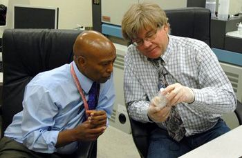 Professor Yemane Asmerom (l.) and Research Scientist Victor Polyak examine a sample. Polyak, who is Asmerom's research partner, manages the UNM Radiogenic Isotope Laboratory.