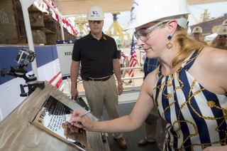 Lynne Mabus, wife of Secretary of the Navy Ray Mabus and sponsor of the amphibious assault ship Tripoli (LHA 7), signs her initials onto the ship’s keel plate this morning at HII’s Ingalls Shipbuilding division in Pascagoula, Miss. She then certified that the keel had been “truly and fairly laid.” Also pictured is Ingalls Shipbuilding President Brian Cuccias. Photo by Lance Davis Tripoli (LHA 7) Keel Authenticated
