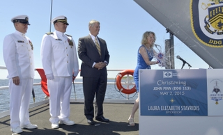 Ship Sponsor Laura Stavridis smashes a bottle of sparkling wine across the bow of the Ingalls-built Aegis destroyer John Finn (DDG 113). Also pictured (left to right) are Master Chief Petty Officer of the Navy Michael Stevens; Cmdr. Micheal Wagner, prospective commanding, John Finn; and Ingalls Shipbuilding President Brian Cuccias. Photo by Andrew Young/HII John Finn (DDG 113) is christened