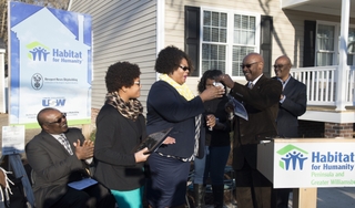 Ray Bagley, Newport News Shipbuilding’s vice president of trades operations, presents the house keys to LaShand Coleman and her family during Wednesday’s Habitat for Humanity dedication ceremony. The Coleman house is the 13th Habitat for Humanity house built by shipyard volunteers. Photo by Ricky Thompson/HII Habitat For Humanity Home Dedication