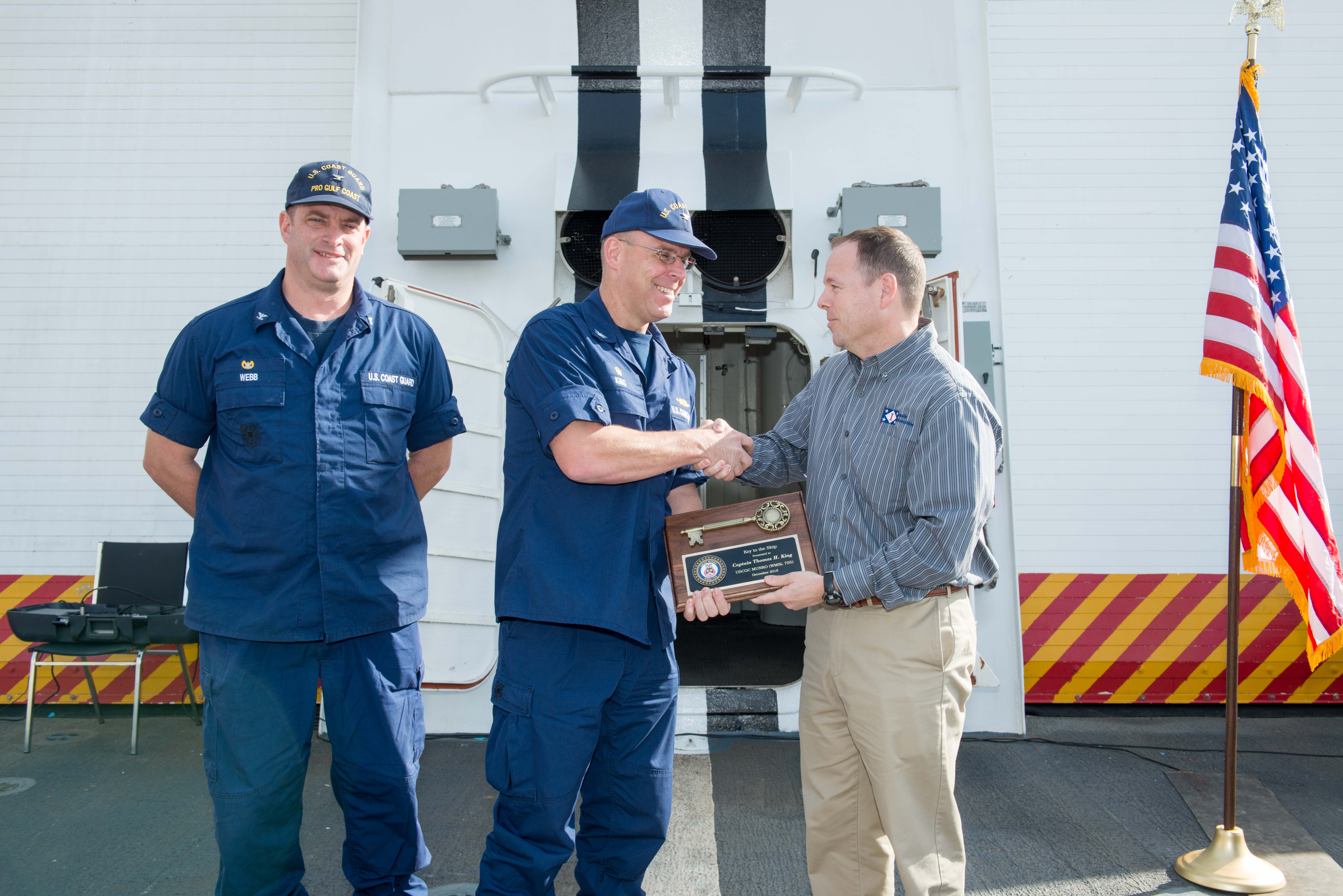 Derek Murphy (right), Ingalls’ NSC program manager, presents the key plaque to Capt. Thomas King, Munro’s commanding officer, with Christopher Webb, commanding officer of the U.S. Coast Guard’s Project Resident Office Gulf Coast, observing. Photo by Andrew Young/HII Munro Key Plaque Presentation