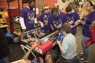 Newport News Shipbuilding Engineer Lewis Fisher (left) mentors members of the Royal Robotics team from Churchland High School as they put the final touches on their robot. Royal Robotics was one of 34 teams that competed in the worldwide robotics challenge for high school students. Photo by Matt Hildreth FIRST Robotics Competition