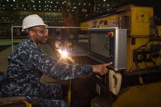 Cmdr. Dave Murray, post-delivery officer for the U.S. Navy’s DDG 51 program, presses the button to start fabrication of the Ingalls-built destroyer Frank E. Petersen Jr. (DDG 121). Photo by Lance Davis/HII DDG Start Fab
