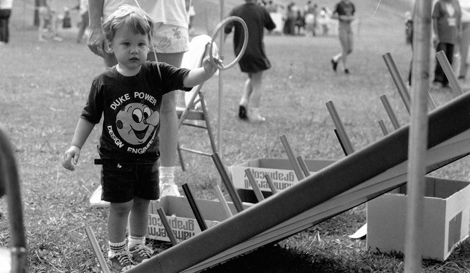 This photo was taken at Camp Thunderbird at Lake Wylie, S.C., in 1988. The event appears to be a Duke Power Design Engineering festival ("DE FEST"). Who is the child and what does he look like now? boy 27