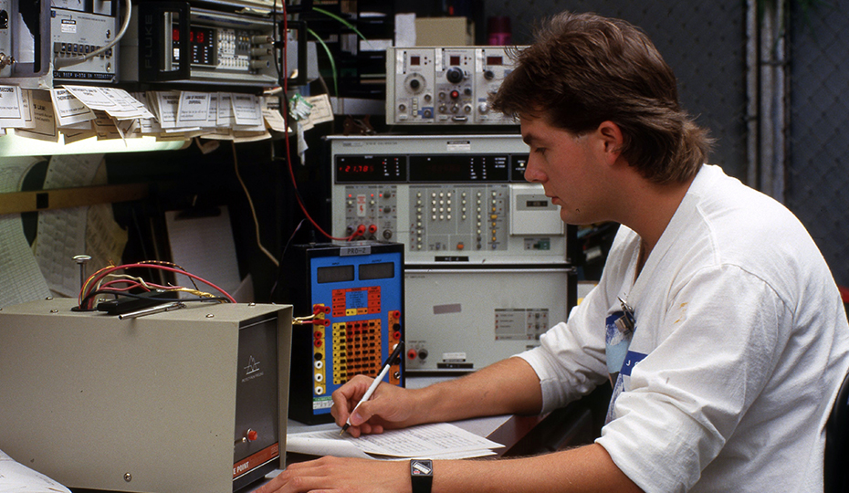 This photo was shot at Carolina Power & Light's Brunswick nuclear plant in 1987. Who is it and what is he doing? Young man at controls c1980 0516