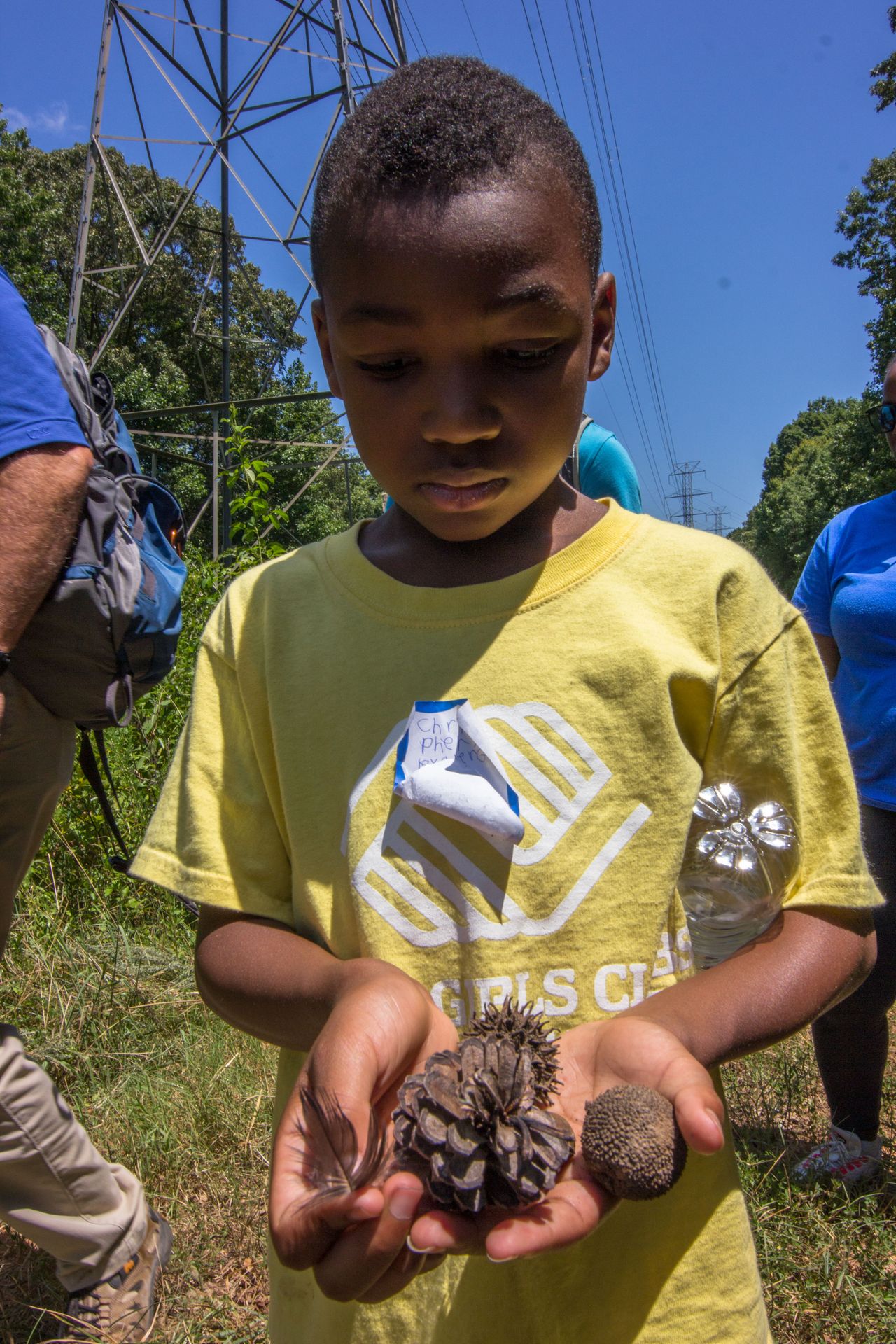 Chris displays his collection from the hike including a pinecone, duck feather and sycamore seed. Label-1