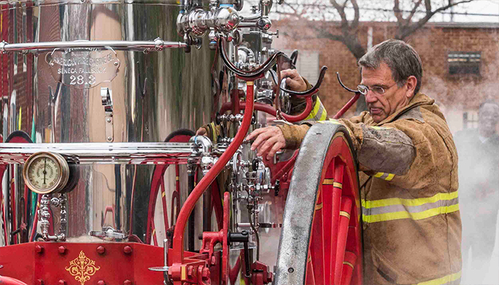 Charlotte Fire Chief Jon Hannan, at right of pumper, mans the controls during testing. 20170321OldSue_4_700
