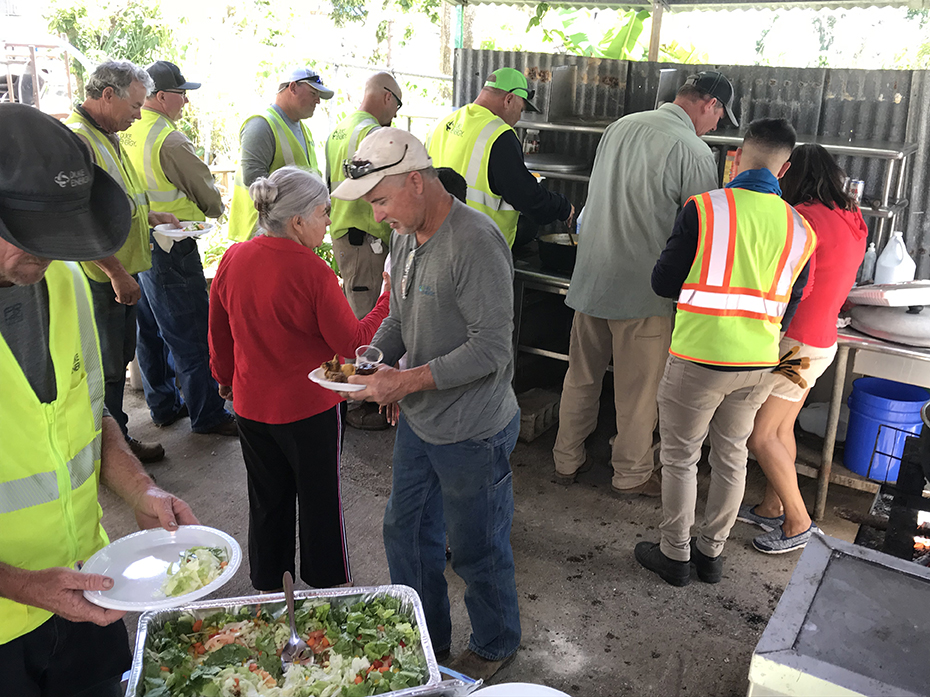 Linemen fix their plates at the home of a customer whose power they recently restored. The family made them this lunch as a thank you. 2018-0215-Mosier-Puerto-Rico-1