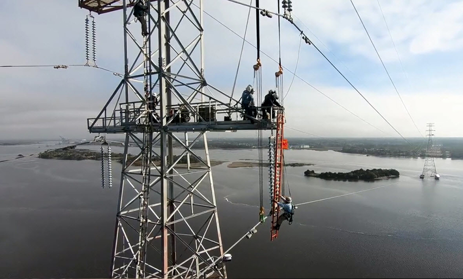 Duke Energy crews climbed the 335-foot transmission tower and raised the bottom power line to give the cranes enough clearance to pass. 2018-0402-Wilmington-Cranes-930-2